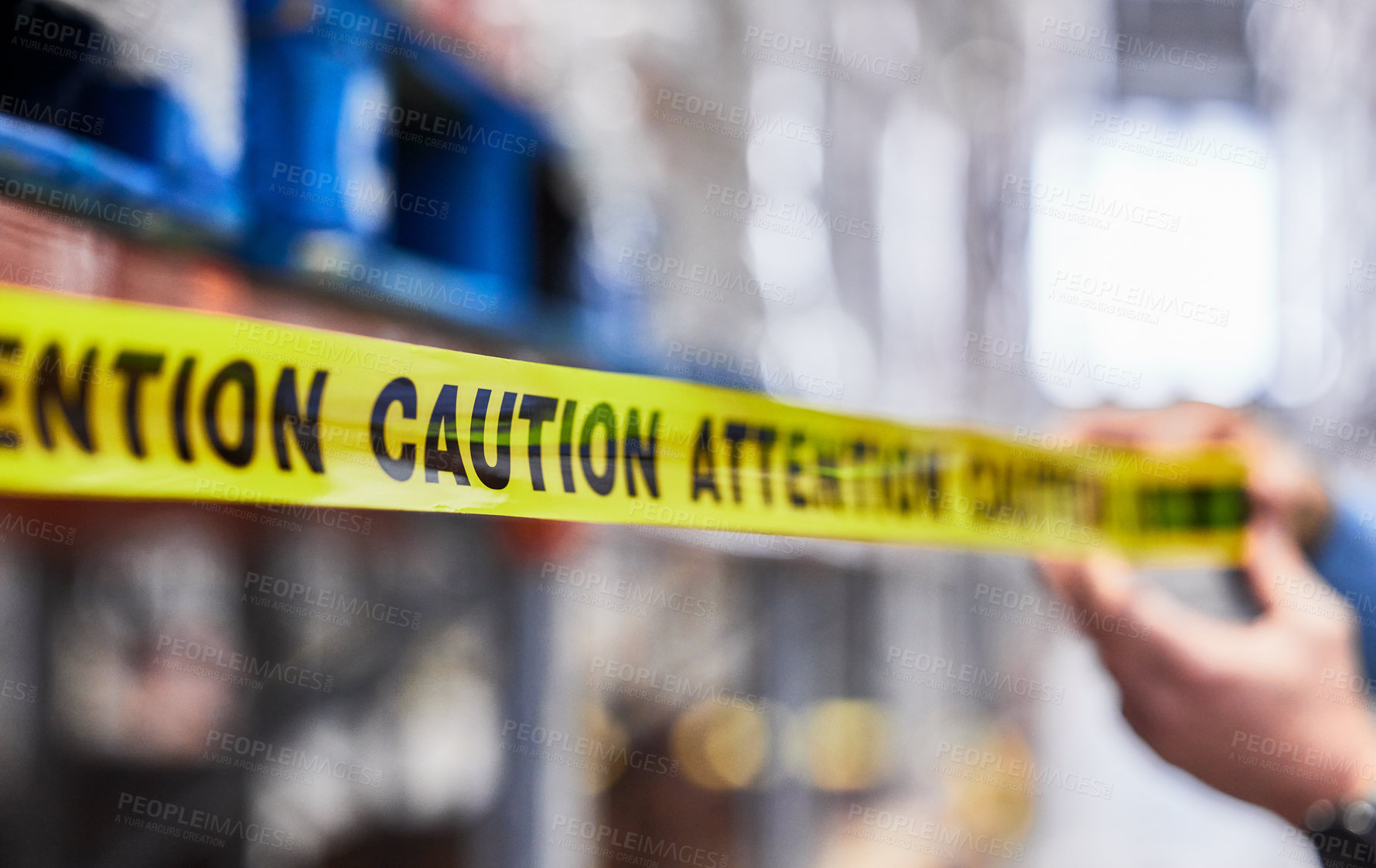 Buy stock photo Shot of a unrecognizable man putting up tape in a warehouse