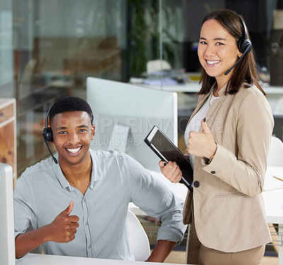 Buy stock photo Shot of a young man and woman showing thumbs up while using a computer while working in a call centre