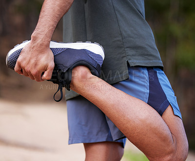 Buy stock photo Closeup shot of an unrecognisable man stretching his legs while exercising outdoors