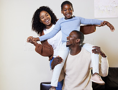 Buy stock photo Shot of two young parents bonding with their daughter during a day at home