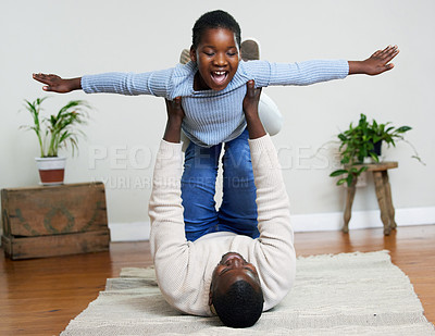Buy stock photo Shot of a happy young girl bonding with her father in the living room at home