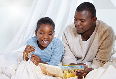 Buy stock photo Shot of a handsome young man lying down with his daughter at home under a sheet fort