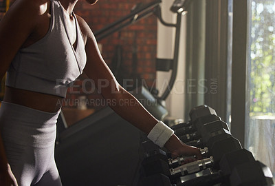 Buy stock photo Woman, fitness and weightlifting with dumbbell at gym for workout, training or indoor exercise. Active female person or hands with small weights by rack for strength or muscle gain at health club