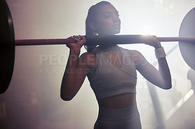 Buy stock photo Shot of a sporty young woman getting ready to do a barbell overhead press in a gym