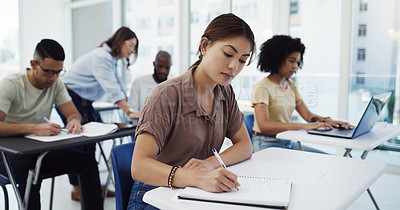 Buy stock photo Woman, students and writing with test in classroom for exam, study or assignment at university. Female person or group busy on project or essay with notebook for higher education, lesson or learning
