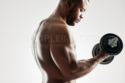 Buy stock photo Studio shot of an young man working out with a dumbbell against a grey background