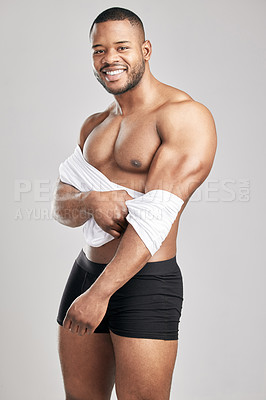 Buy stock photo Strong, African man and happy portrait with shirt in studio for confidence, pride and fitness in underwear. Bodybuilder, athlete and smile with body care by white background for health and wellness
