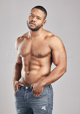 Buy stock photo Studio shot of a young muscular man posing against a grey background