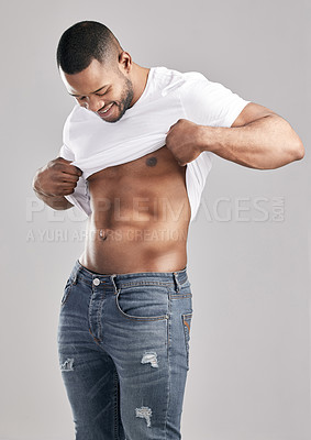 Buy stock photo Studio shot of a young muscular man posing against a grey background