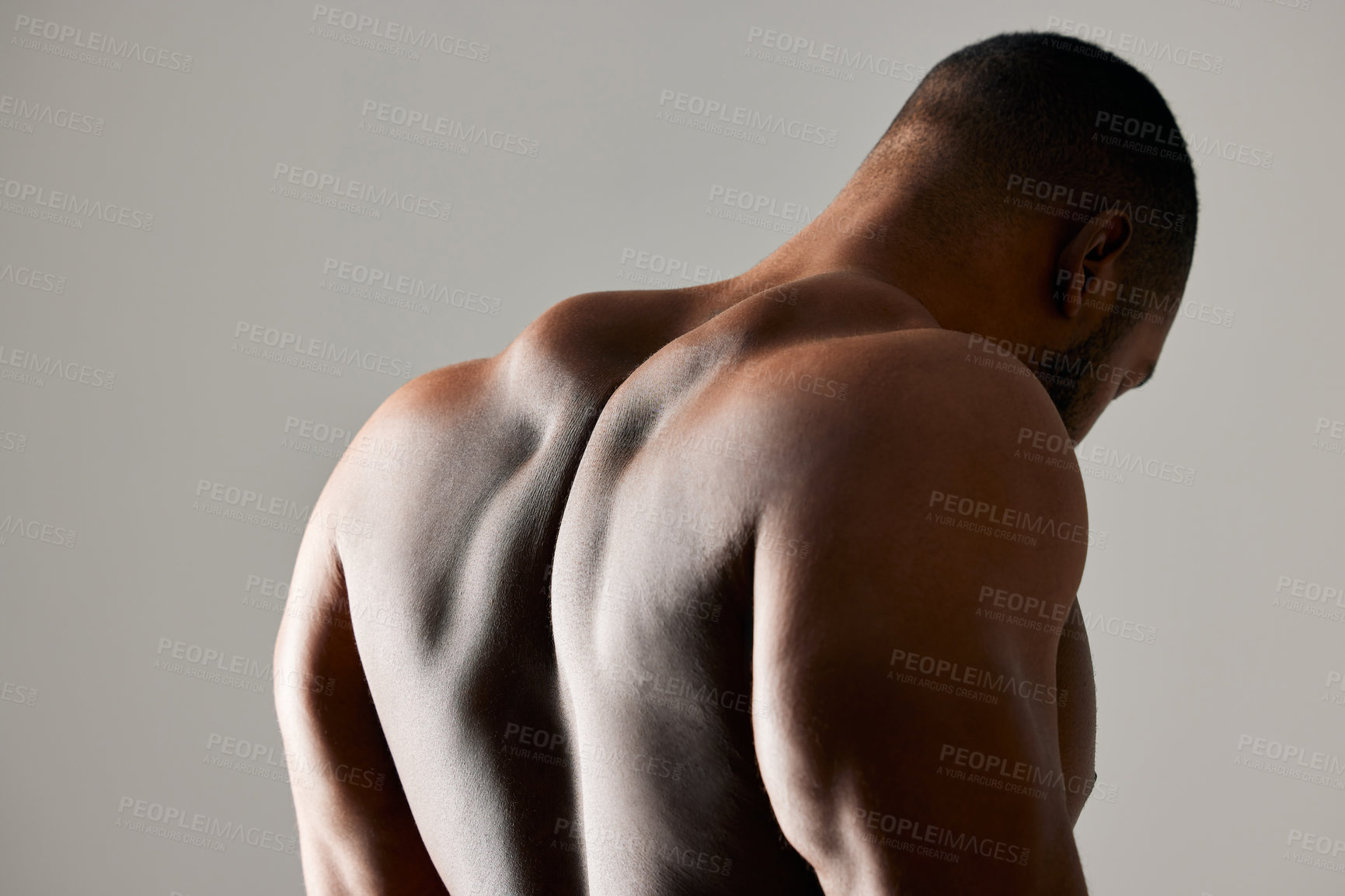 Buy stock photo Back, closeup and man in studio with body health, strong for fitness and exercise in gym. Bodybuilder, sports and gray background with muscle of model for training, zoom for anatomy or growth
