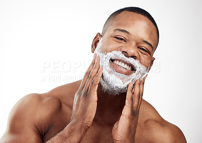 Buy stock photo Studio portrait of a handsome young man applying shaving cream to his face against a white background