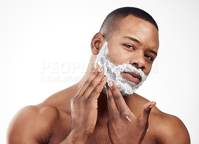 Buy stock photo Studio portrait of a handsome young man applying shaving cream to his face against a white background