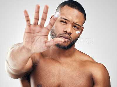 Buy stock photo Studio portrait of a handsome young man with moisturiser on his face and finger against a white background