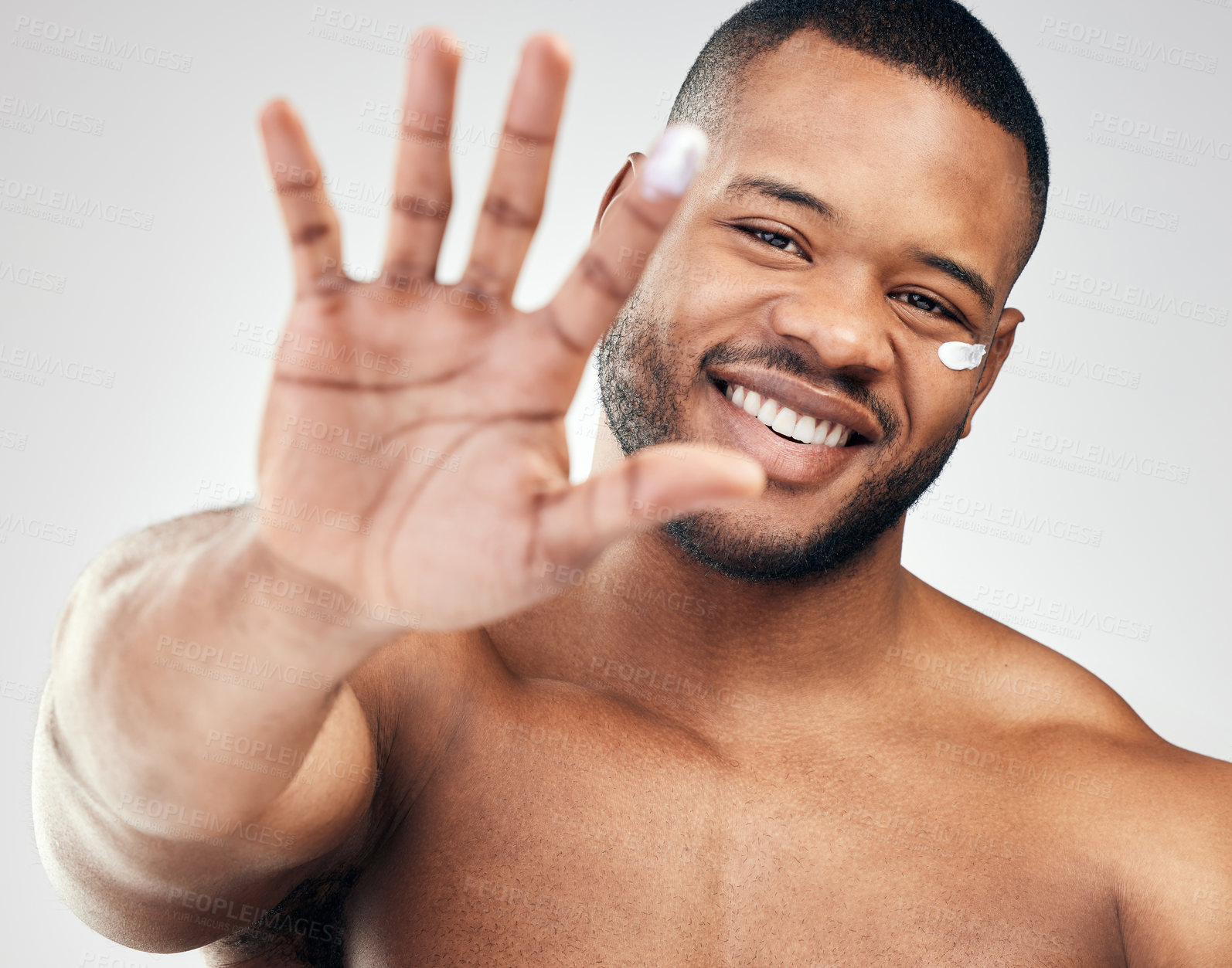 Buy stock photo Studio portrait of a handsome young man with moisturiser on his face and finger against a white background