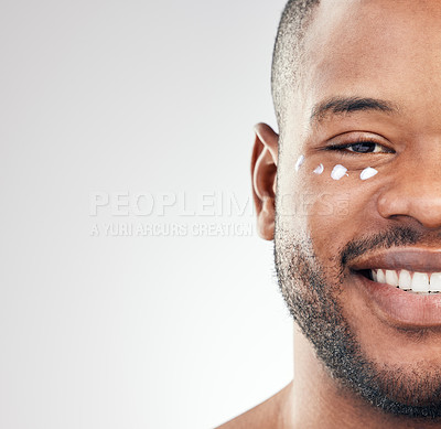 Buy stock photo Studio portrait of a handsome young man posing with moisturiser on his face against a white background