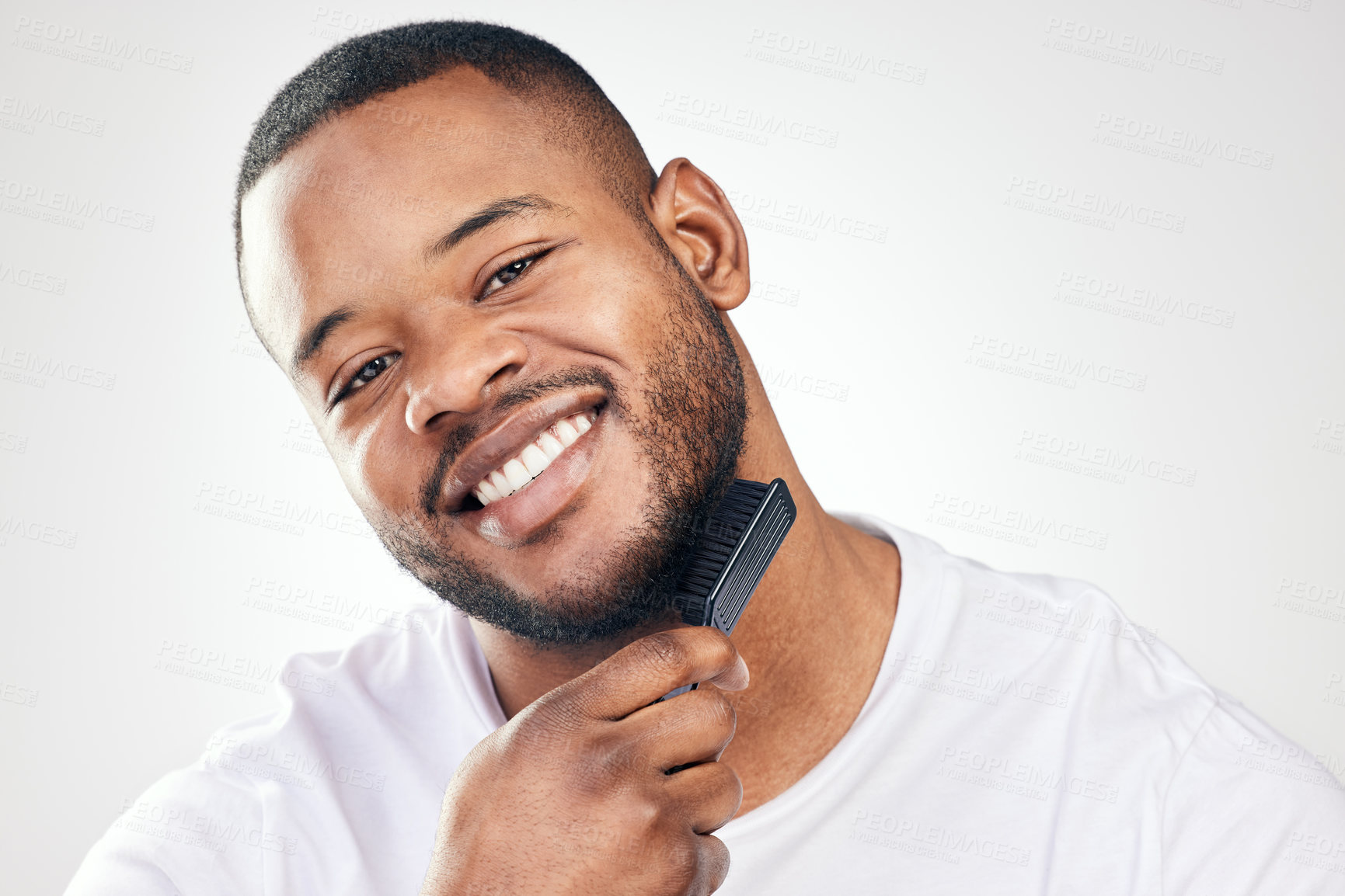 Buy stock photo Black man, portrait and beard brush in studio for hair grooming or healthy hygiene, white background or self care. Male person, face and comb tool or morning routine for beauty, maintenance or smile