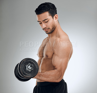 Buy stock photo Shot of a man working out with weights while standing against a grey background