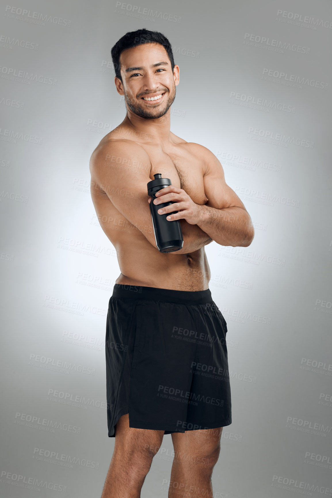 Buy stock photo Fitness, smile and water bottle with shirtless man in studio on gray background for health or hydration. Body, exercise and portrait with happy sports person in shorts for training or workout