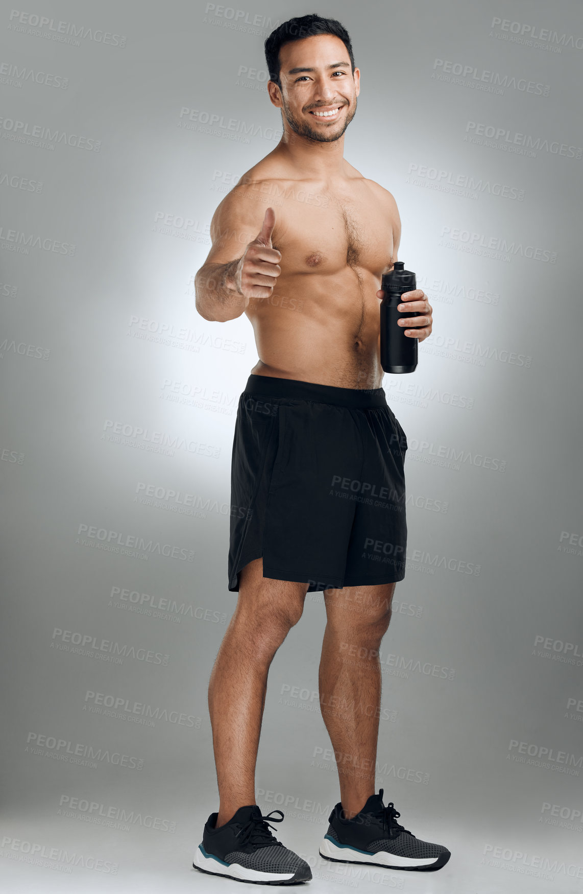 Buy stock photo Water bottle, thumbs up and portrait of man in studio with fitness, exercise and muscle training. Smile, workout and shirtless athlete with satisfaction gesture for bodybuilding by gray background.