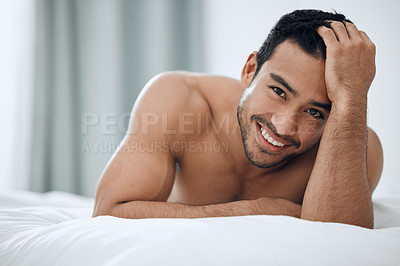 Buy stock photo Shot of a handsome young man lying on his bed