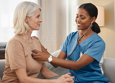 Buy stock photo Shot of a doctor examining a senior woman with a stethoscope at home