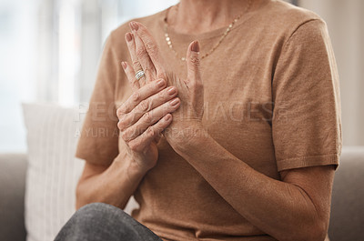Buy stock photo Shot of an unrecognisable woman experiencing pain in her hand at home