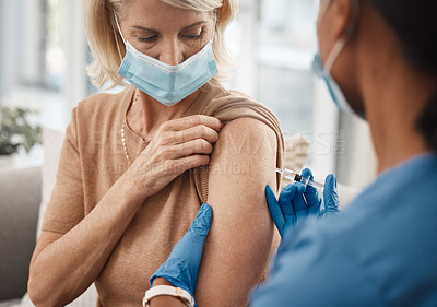 Buy stock photo Shot of a doctor giving a senior woman an injection at home