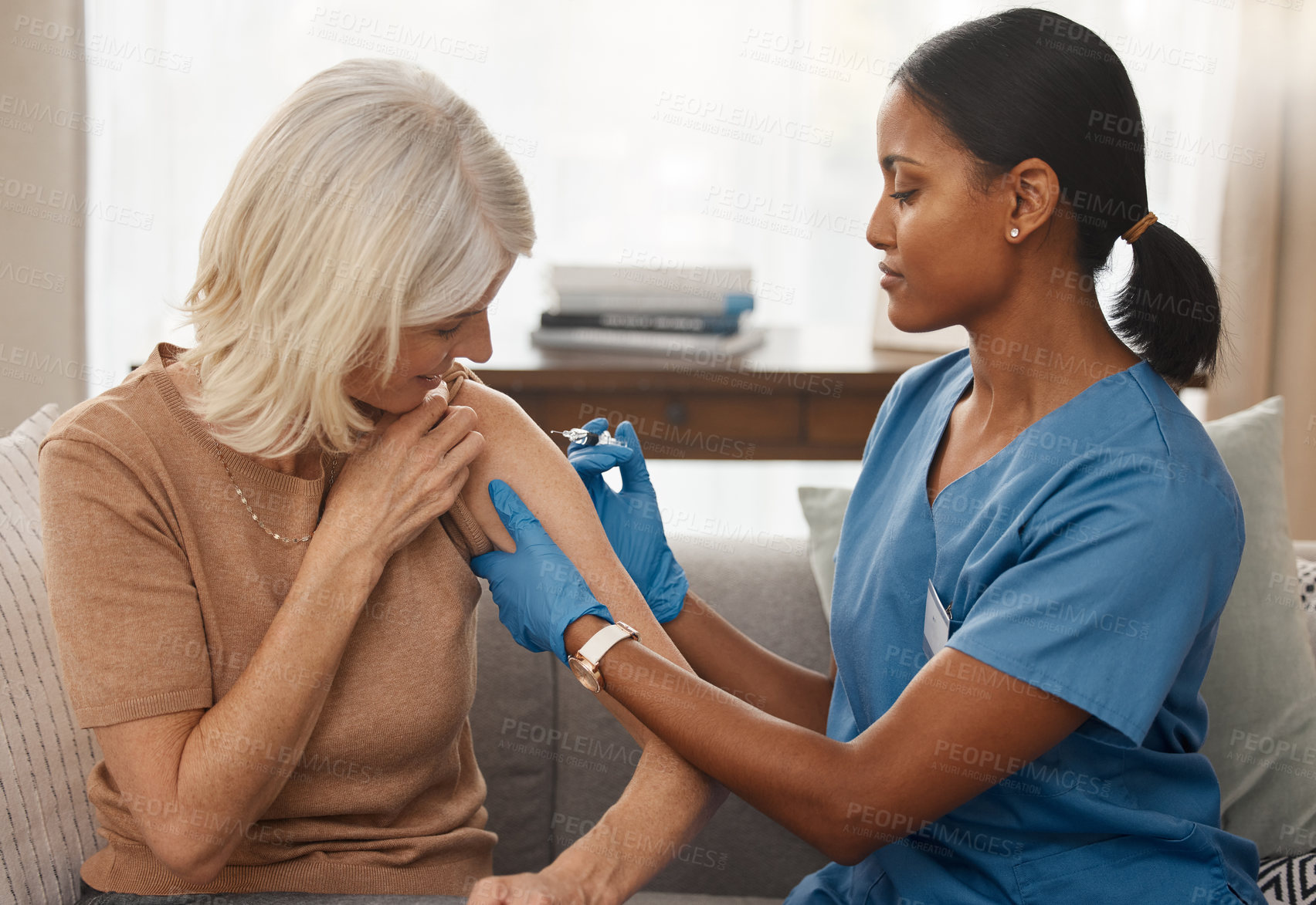 Buy stock photo Shot of a doctor giving a senior woman an injection at home