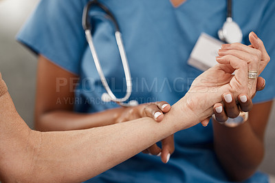 Buy stock photo Shot of a doctor examining a senior woman’s pulse during a consultation at home