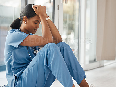 Buy stock photo Shot of a young doctor looking distressed
