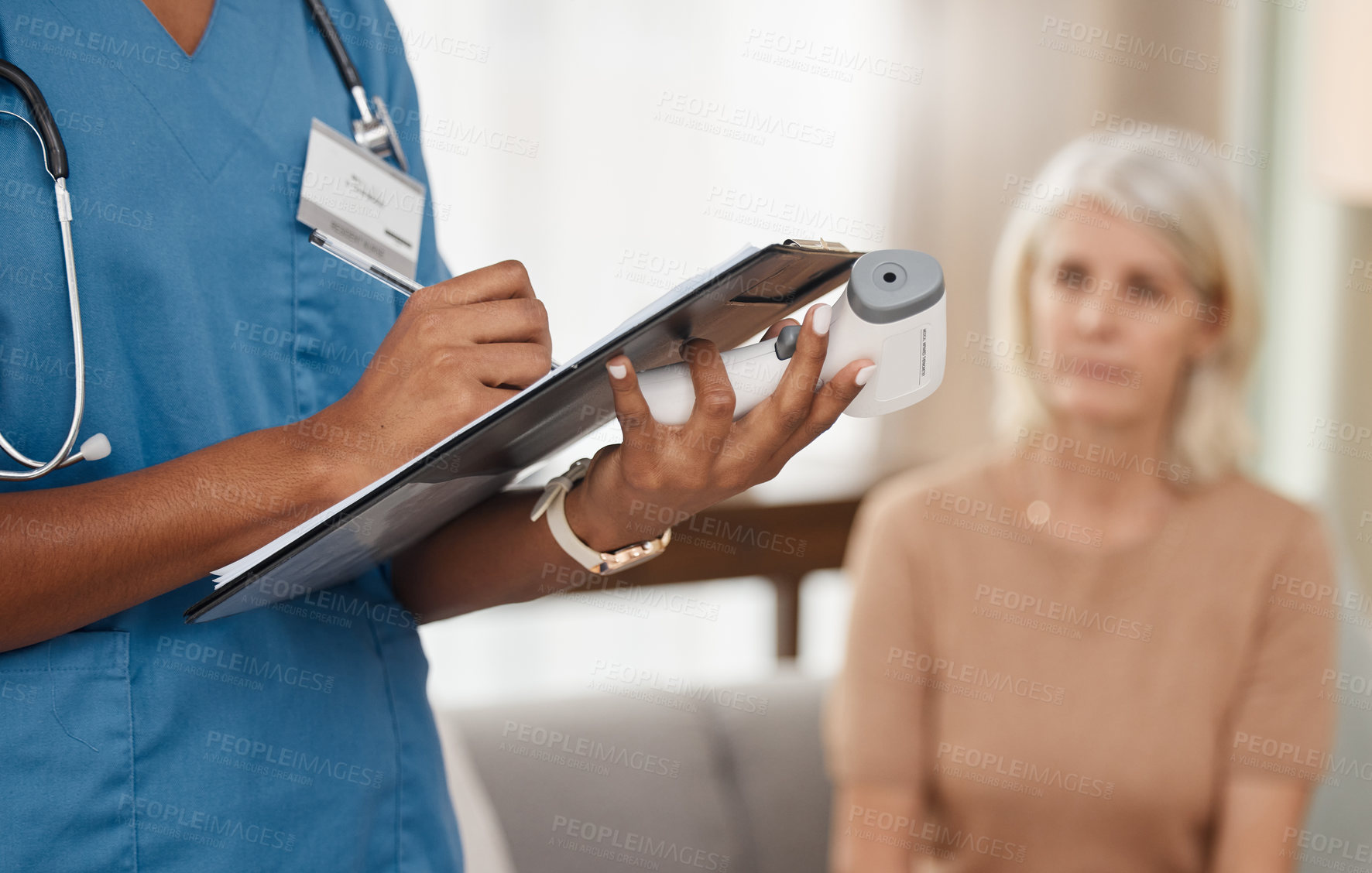 Buy stock photo Shot of a doctor filling out a questionnaire during a consultation with a senior woman at home