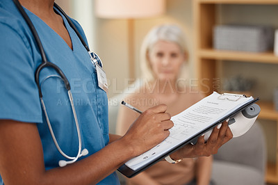 Buy stock photo Shot of a doctor filling out a questionnaire during a consultation with a senior woman at home