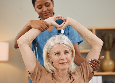 Buy stock photo Shot of a senior woman using dumbbells during an exam with her doctor at home
