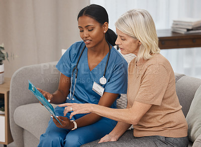 Buy stock photo Shot of a doctor reading a pamphlet about Covid-19 on the sofa at home