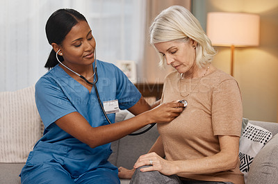 Buy stock photo Shot of a doctor examining a senior woman with a stethoscope at home