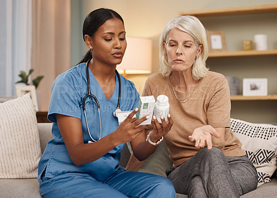 Buy stock photo Shot of a doctor discussing medication options during a a consultation with a senior woman at home