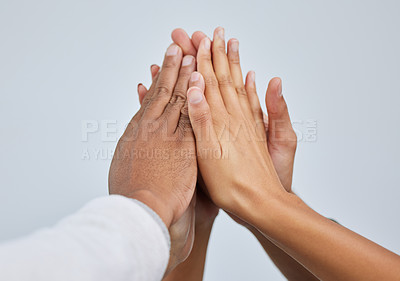 Buy stock photo Closeup shot of a group of people giving each other a high five against a white background