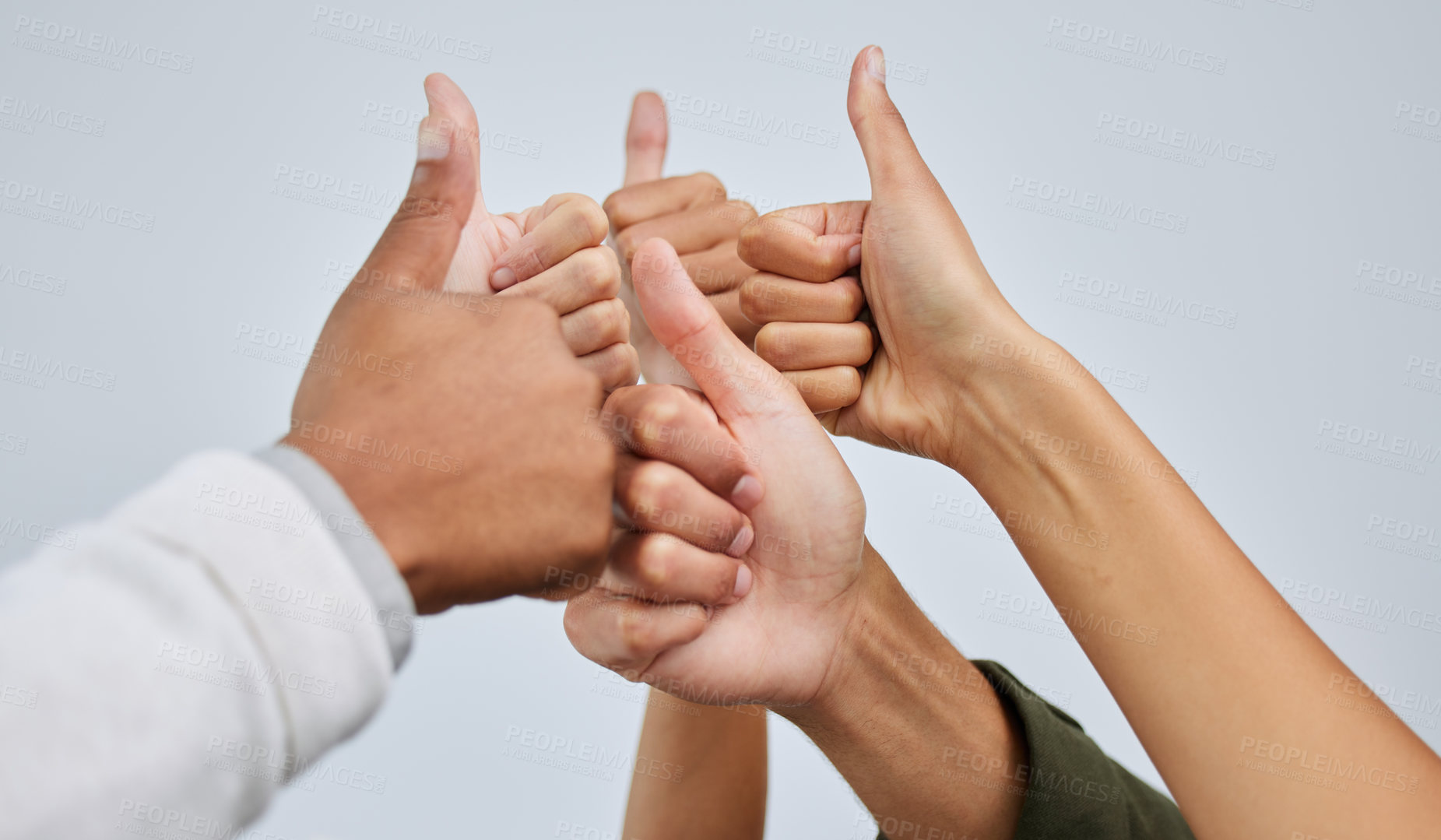 Buy stock photo Closeup shot of a group of people showing thumbs up together against a white background