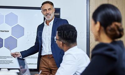 Buy stock photo Shot of a mature businessman giving a presentation to his colleagues in an office