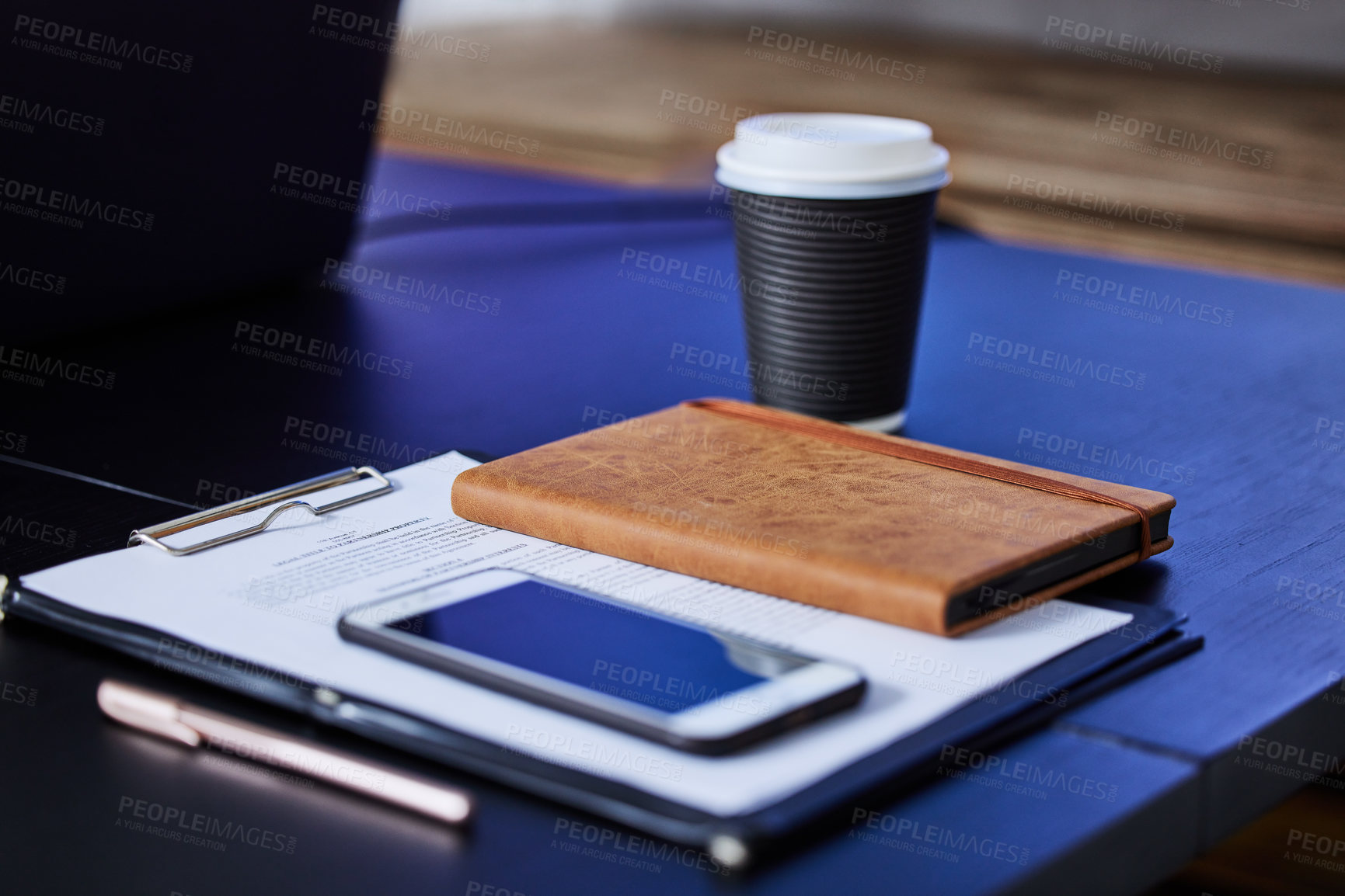 Buy stock photo Closeup shot of a cellphone, diary and paperwork on a table in an office