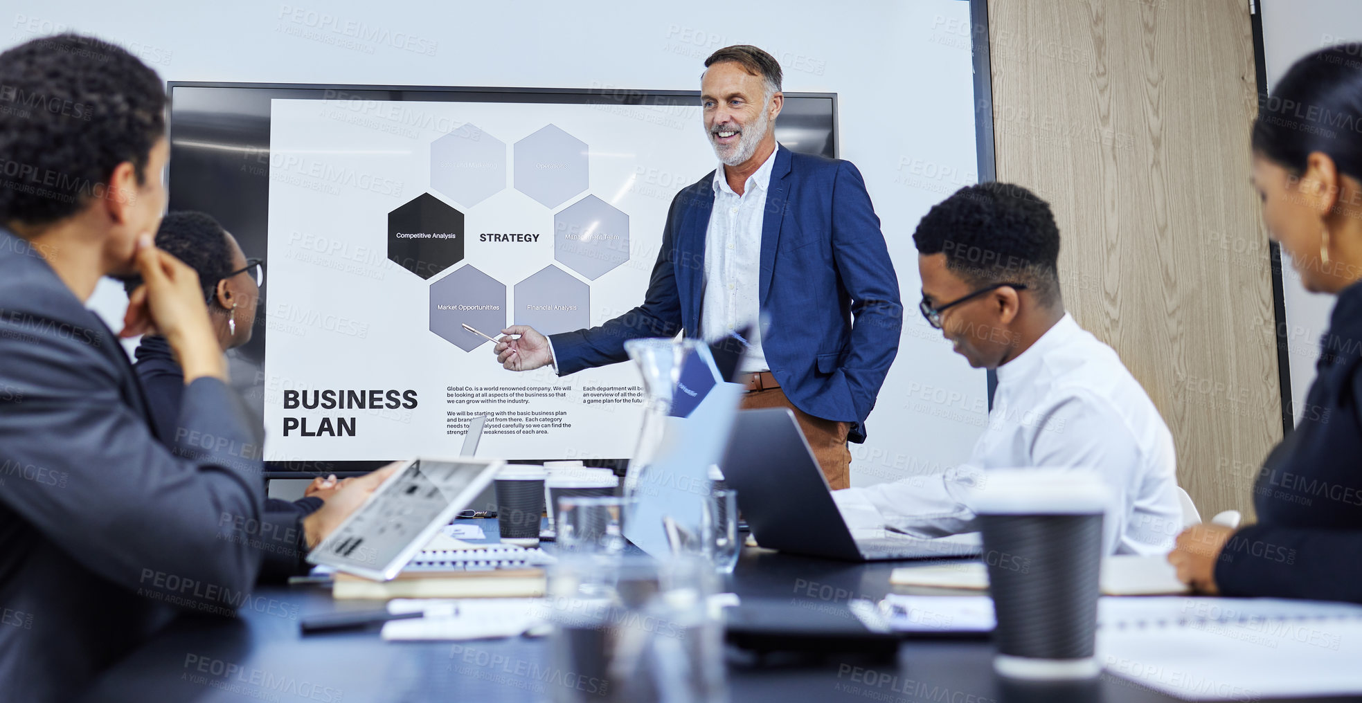 Buy stock photo Shot of a mature businessman giving a presentation to his colleagues in an office