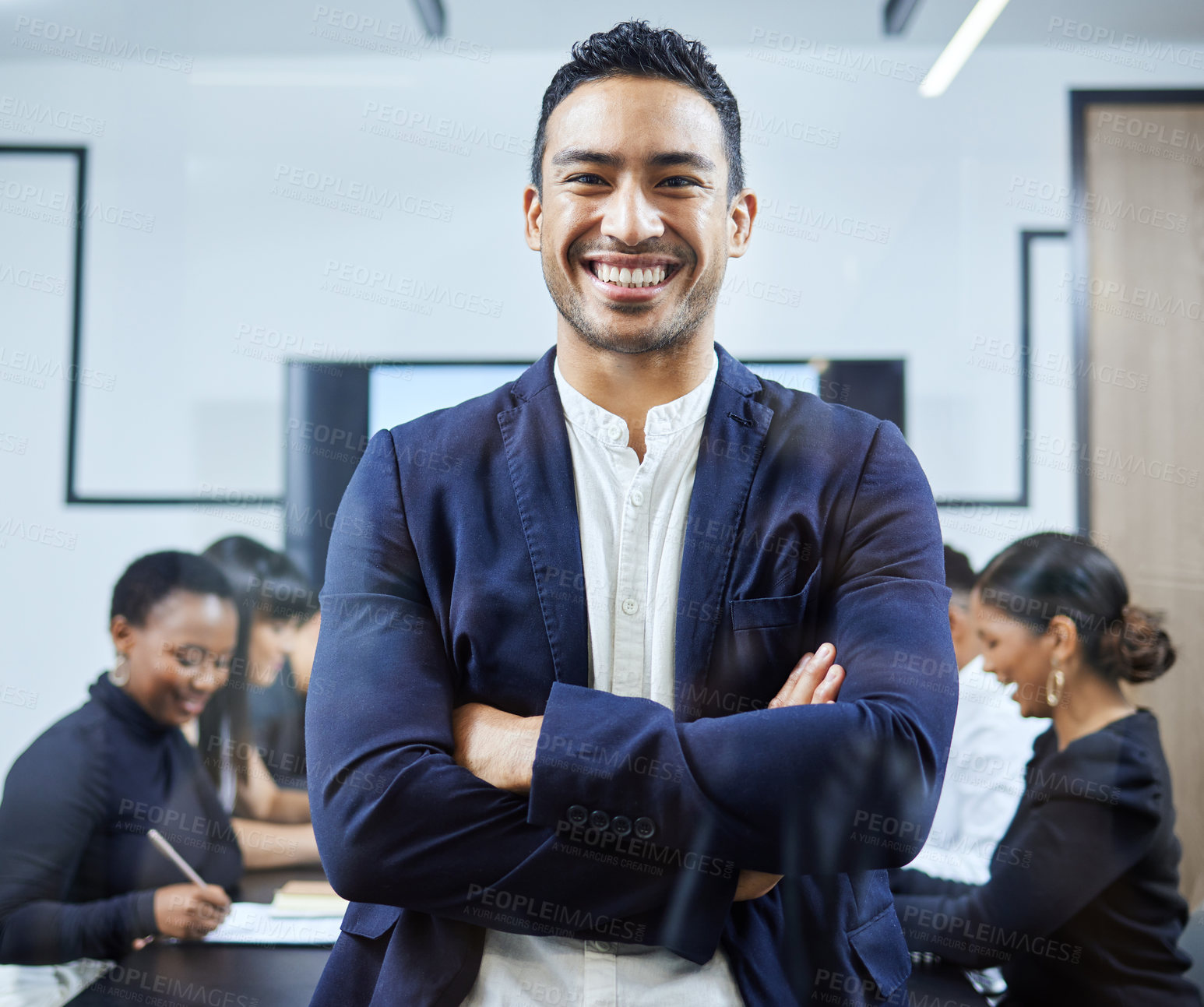 Buy stock photo Portrait of a young businessman standing in an office with his colleagues in the background