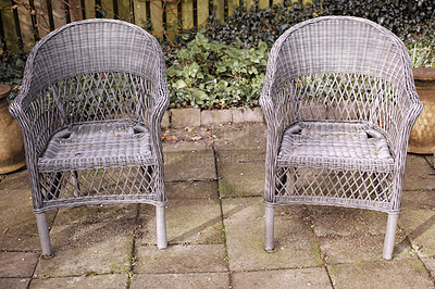 Buy stock photo Two relaxing garden chairs and seating in a private and secluded courtyard at home to enjoy mother nature and fresh air. Serene, tranquil and peaceful backyard area with comfortable wicker furniture