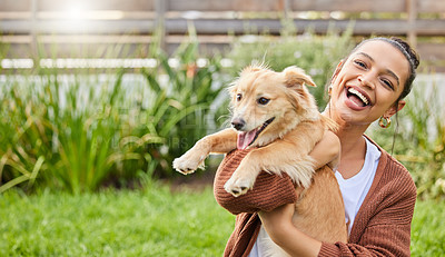 Buy stock photo Portrait of an attractive young woman playfully holding her dog in the garden