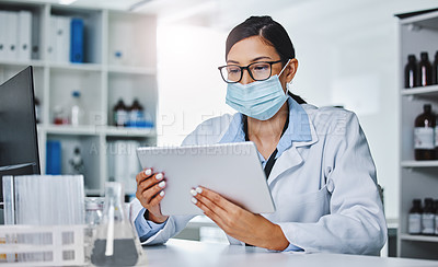 Buy stock photo Shot of a young female researcher using a digital tablet in a laboratory