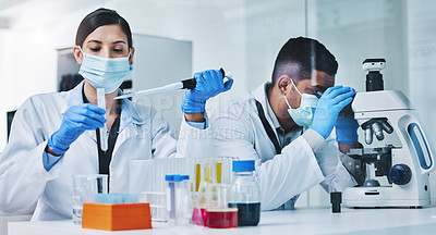 Buy stock photo Shot of two young researchers working in a laboratory