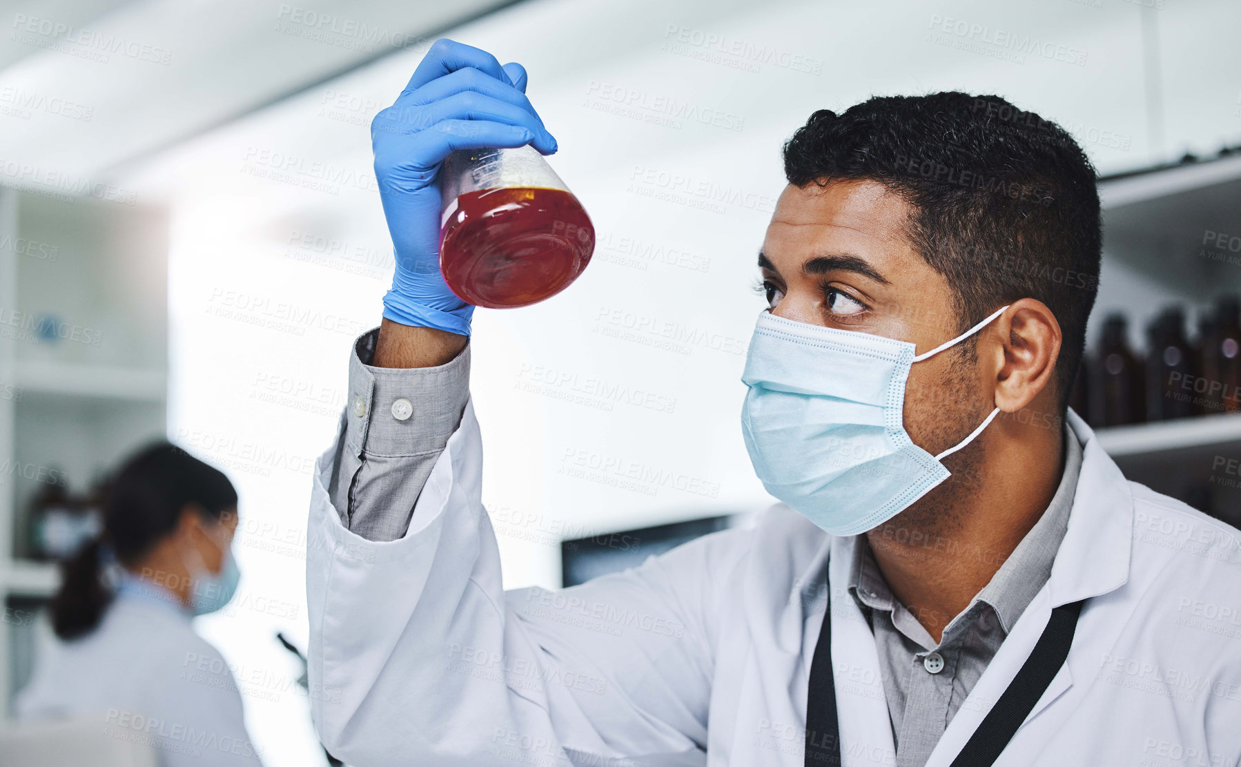 Buy stock photo Shot of a young male researcher working in a laboratory