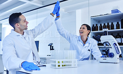 Buy stock photo Cropped shot of two young scientists high fiving while working in their lab
