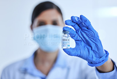 Buy stock photo Cropped shot of an unrecognizable female scientist holding up a bottle of the covid 19 vaccine