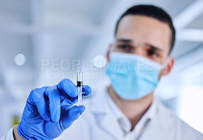 Buy stock photo Cropped shot of an unrecognizable male scientist holding up a syringe containing medication